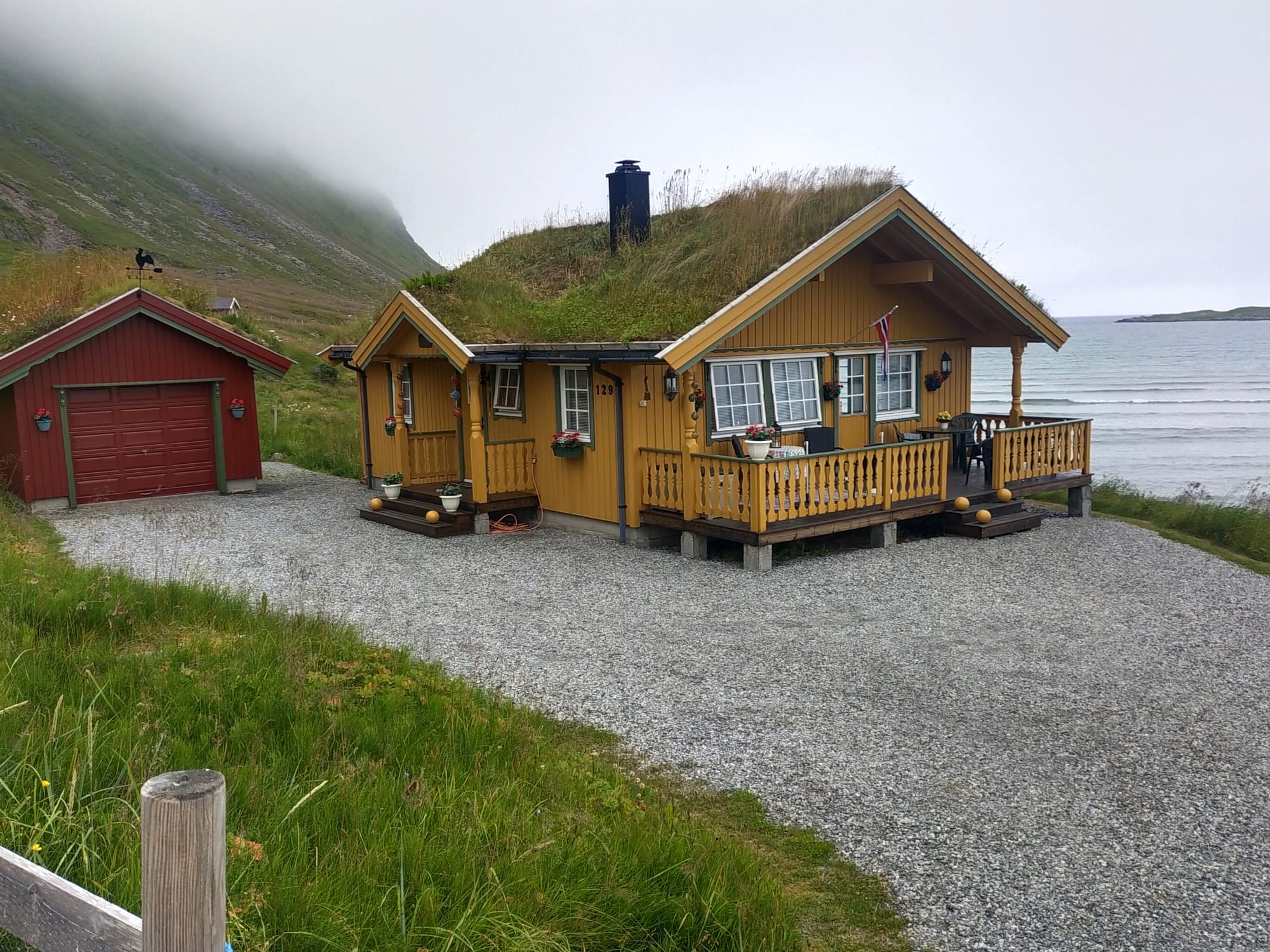 casa con tejado de hierba en noruega junto al fiordo